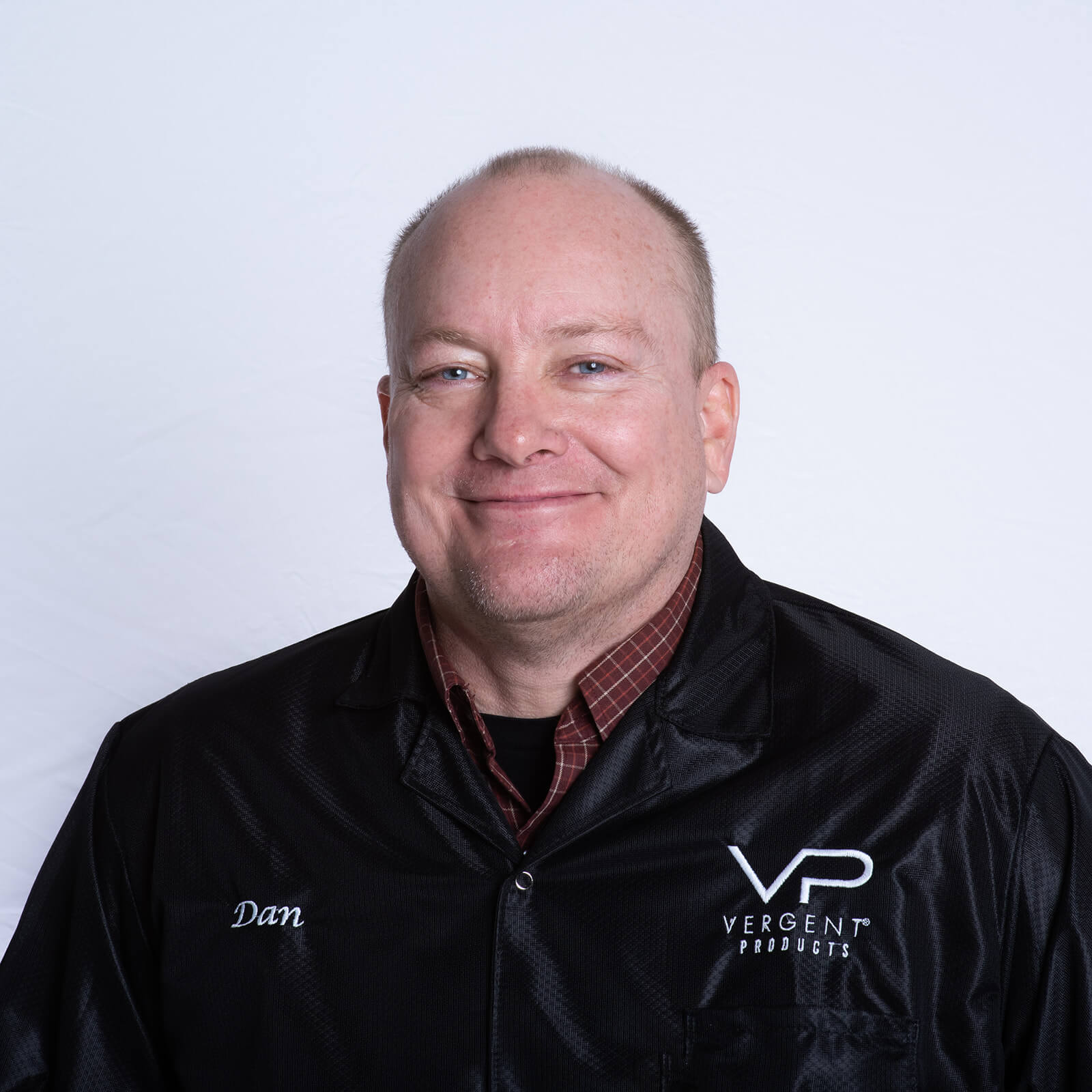 Portrait of a smiling man named Dan wearing a black jacket with "VP Vergent Products" logo.